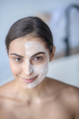 Woman applying face cream during beauty procedures