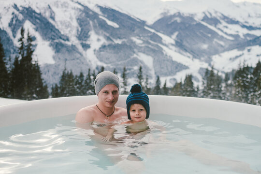 father and son in jacuzzi in alpine winter landscape