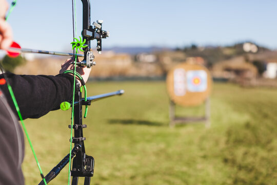 Professional Male Archer Aims at Target Outdoors