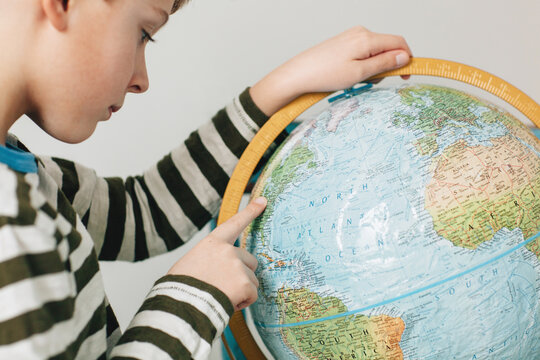 child looking at a globe