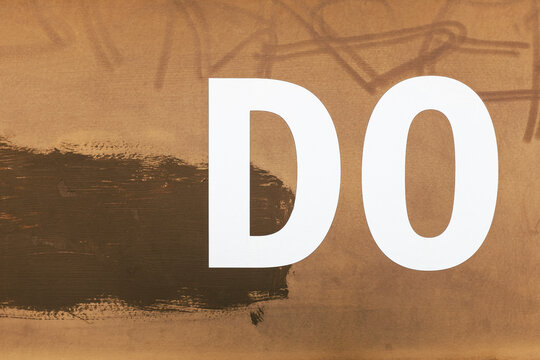 The word "DO" written on rusty, metal wall, close up