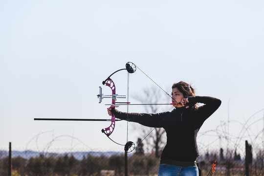 Archer Woman Aiming with Professional Compound Bow Outdoors