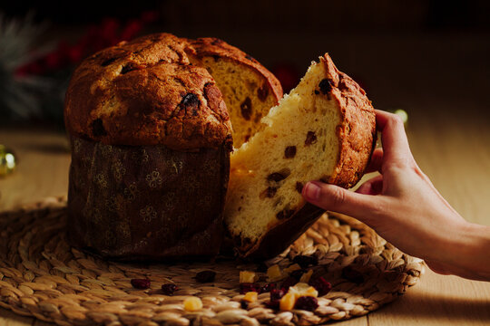 Woman hand taking a piece of Panettone