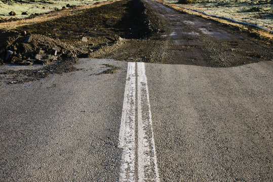 Close shot of road that ends abruptly into a hole.