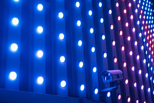 Surveillance camera at the illuminated building facade