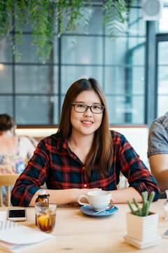 Portrait Of Smiling Asian Woman Sitting At The Coffee Shop