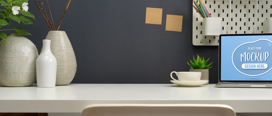 Close-up of modern workspace with mock up laptop computer and decorations