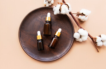Wooden plate with bottles of essential oil