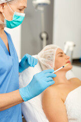 Portrait of woman during beauty facial injections in medical esthetic office. High quality photo