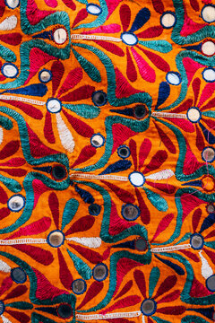 Decorative pattern on a traditional Indian piece of fabric with warm colours. India texture