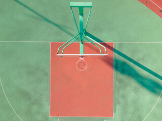 Drone aerial view of the basketball field half court basketball stands hoop. Green basketball court and hoop in the sunny day. Quite no people view of sports calm city lift concept Shanghai China