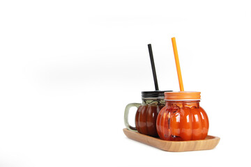 two glasses of pumpkin juice on wooden plate isolated on white background