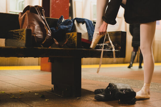 Ballet dancer tying her shoes in New York City subway station