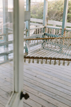Relaxing hammock on porch of home in summer outside door