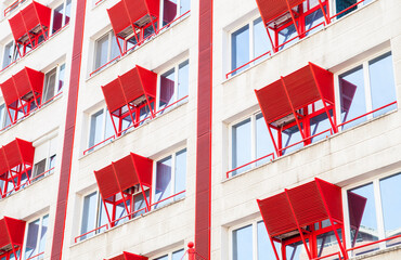 Building facade with red elements on it.