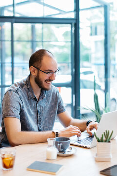 Smiling Caucasian Man With Glasses Working On Laptop