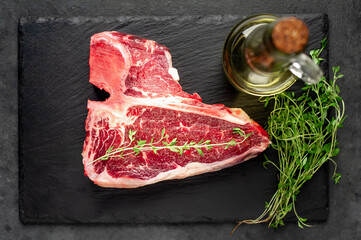 raw t-bone steak with  on stone background