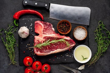 raw t-bone steak with ingredients  on stone background
