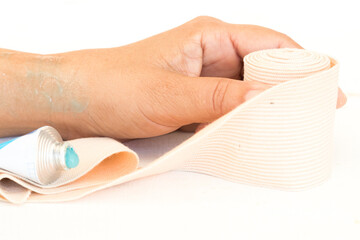 topical medication with roll bandage for first aid accident of wrist woman  on background white