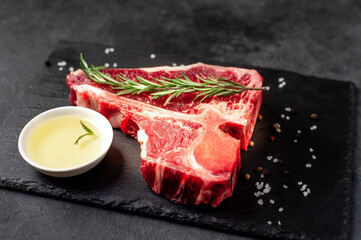 raw t-bone steak with ingredients  on stone background