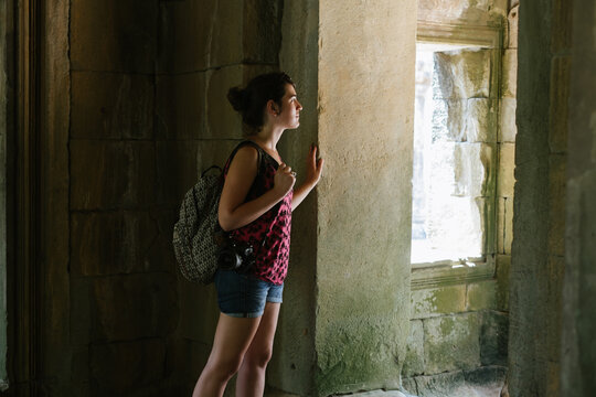 Young Woman Exploring Inside Of The Angkor Wat Temple, Cambodia