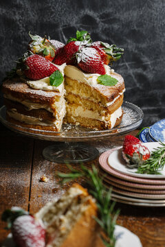 Strawberry and cream sponge with a slice removed.