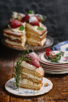 A slice of strawberry and cream genoise sponge cake on table.