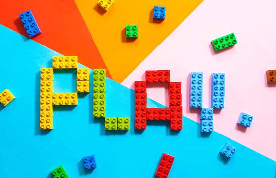 Word Play made from kids bloks on colorful background.