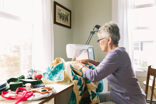 Senior Woman at Home Sewing Quilt