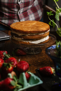 Three layer genoise sponge with cream in the process of being dressed.