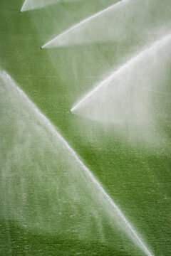 Water sprinklers preparing a sports ground grass.