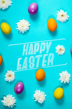 Happy Easter"" text with colorful eggs and white flowers on blue background.