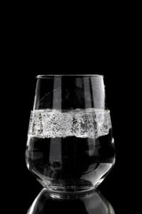  soda water with ice in a glass on a black background