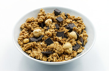 Bowl of mixed Muesli and a cup of white yogurt isolated on white background