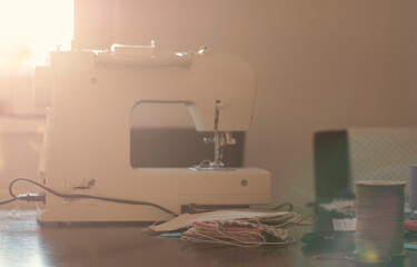 Selective focus on handmade cotton fabric cotton face mask on mat with sewing accessories. Protection against saliva, cough, dust, coronavirus, pollution, virus, bacteria, COVID-19.