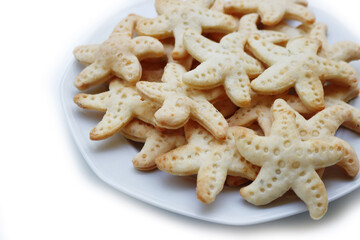 Salty cheese cookies in shape of a starfish on a plate  isolated on white background