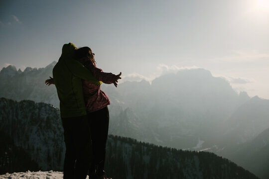 Boyfriend holding his girlfriend like in titanic on top of mountain