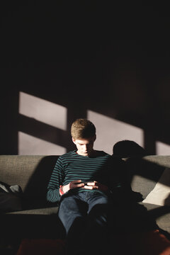Young man using his smartphone in a livingroom