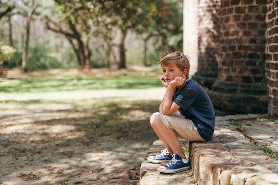 bored boy sitting alone at a park