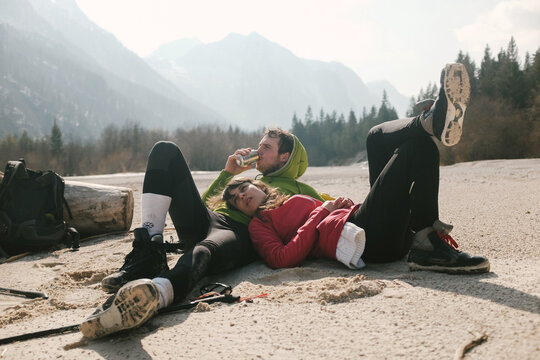 Young couple lying on sand beach during winter
