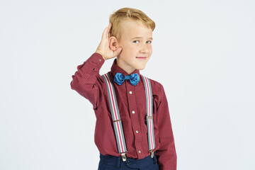 A portrait of a schoolboy who pretends to hear poorly. Isolated background.