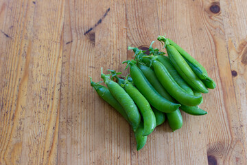Peas in a pod on the wooden table