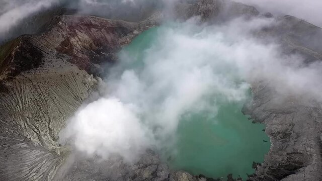 Active volcano kawah Ijen. East Java. Indonesia. Drone flights over the crater. A lake with acid. Extraction of sulfur. Eruption. A pillar of smoke. High quality FullHD footage