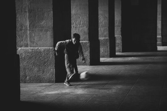 Child Playing Soccer in the Street
