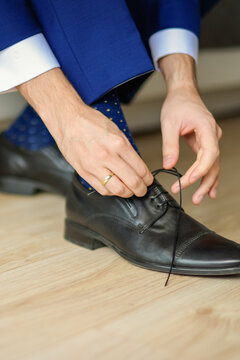 Groom is wearing shoes in blue wedding clothes indoors. The businessman wears shoes