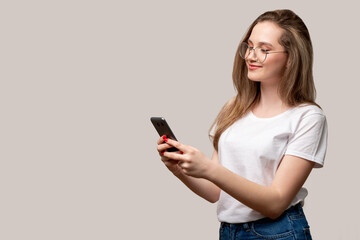 Mobile chat. Online communication. Happy woman reading texting message on phone isolated on gray empty space background. Friendly casual conversation. Social media. New normal.