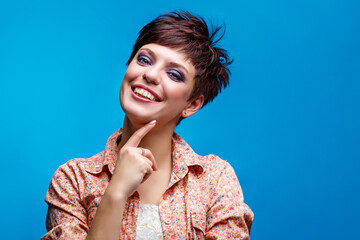 Young smiling lady posing for a photo in the studio. Joy concept. Vibrant colors in life