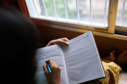 Woman writing a diary by the window