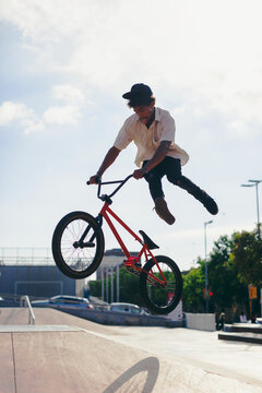 Young boy doing jumps on his BMX bike in a skate park.