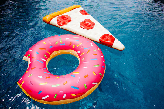 A pizza float and a pink donut float in a blue pool.